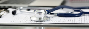 Stethoscope head lying on medical form