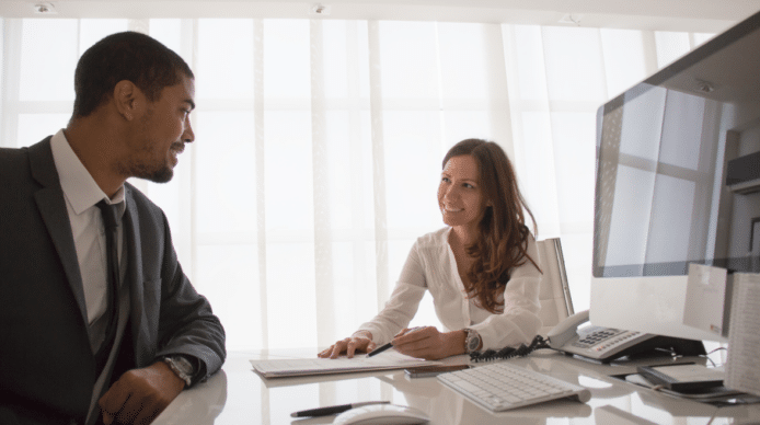Man and woman conferring at a conference table in a sunny room