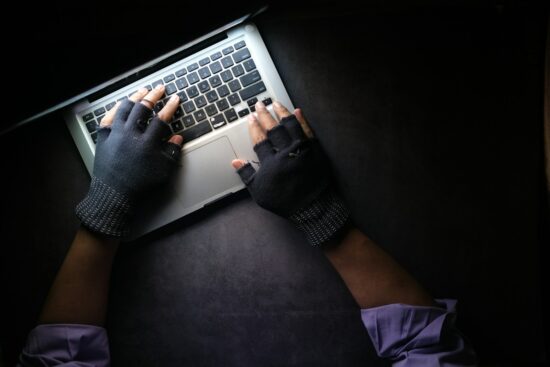 hacker hand stealing data from laptop top down