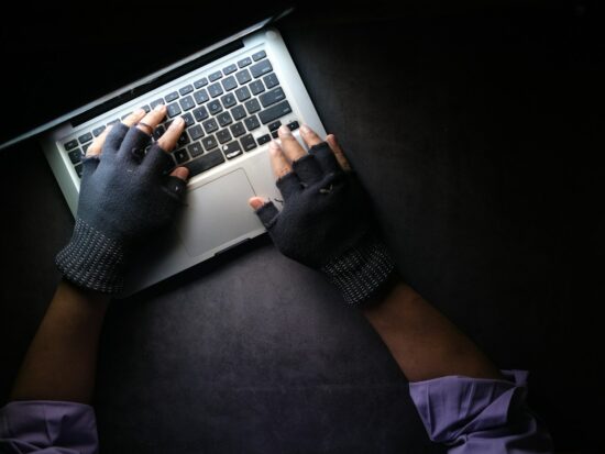 hacker hand stealing data from laptop top down