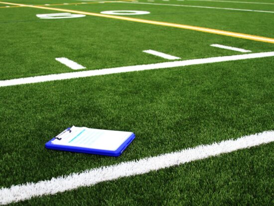 Playbook on a football field in a youth scrimmage.