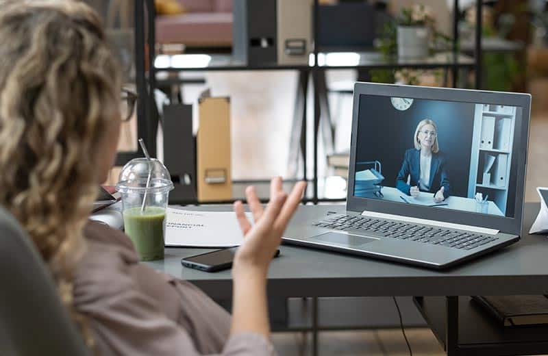 Lawyer talking to their client via video call in their office.