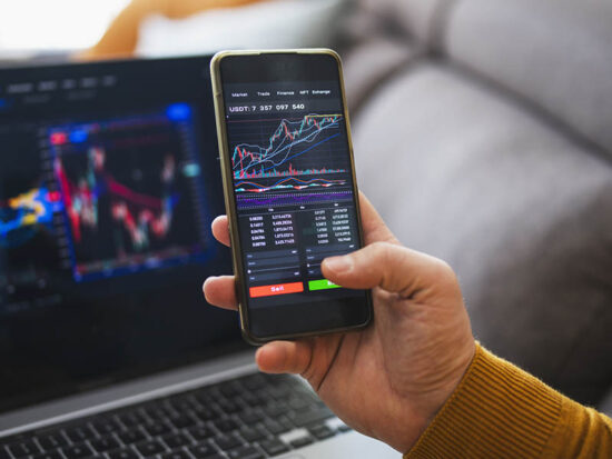 Man buying cryptocurrency at home via laptop and phone.