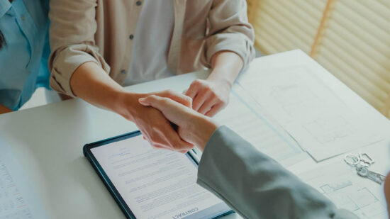 Close-up of Asian tenants sign house agreements on tablet and give them to female real estate agent after showing new houses. Landlord selling real estate to customers for investment.