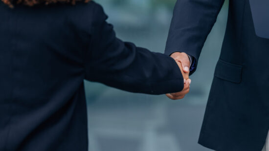 Two business professionals shaking hands in an office setting