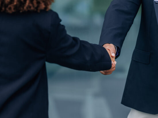 Two business professionals shaking hands in an office setting