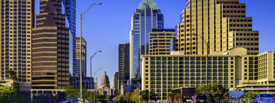 Downtown Austin skyscrapers surrounding Texas Capitol with busy cars, people