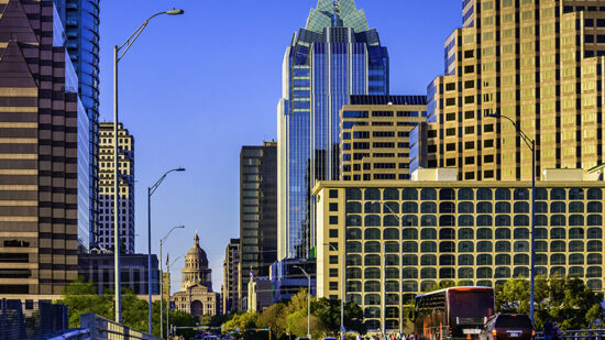 Downtown Austin skyscrapers surrounding Texas Capitol with busy cars, people