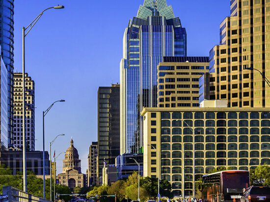 Downtown Austin skyscrapers surrounding Texas Capitol with busy cars, people
