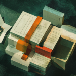 Watercolor-style illustration of modular building blocks forming a folder shape with document pages and a photograph, dark green textured background with red and gold accents